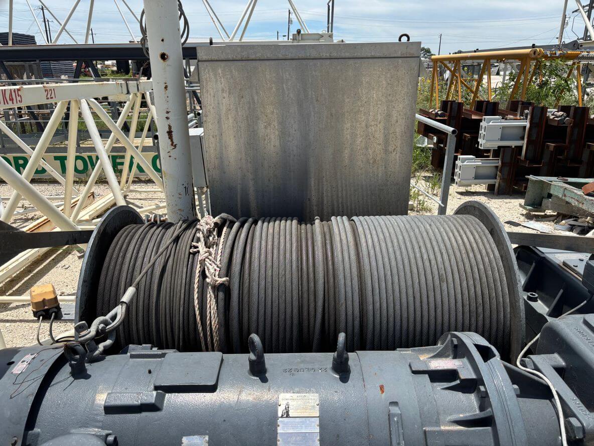 Large industrial winch with heavy-duty steel cables on a dock.
