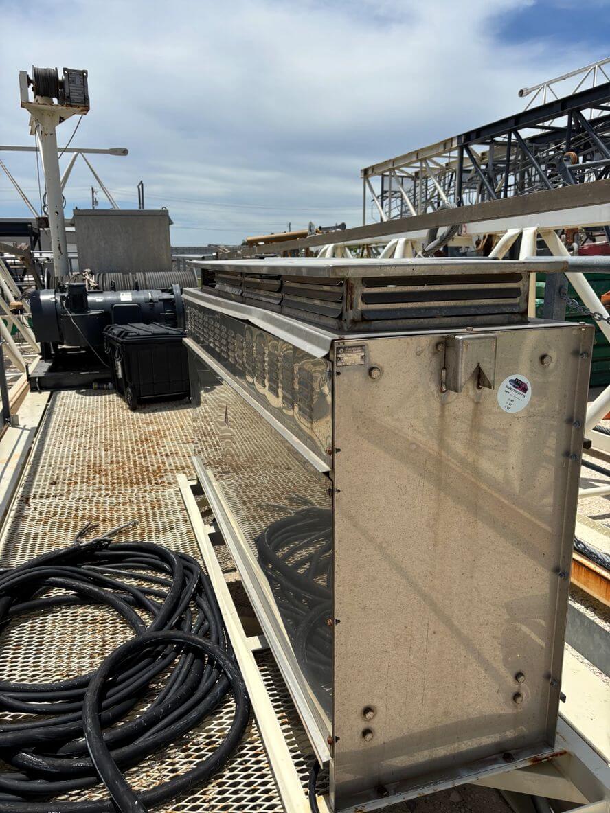 A long metal beam with cables coiled nearby on an industrial site.
