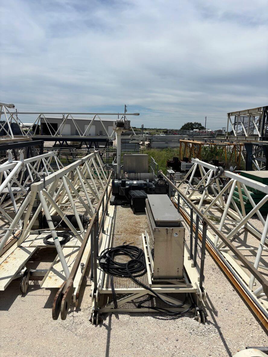 View of industrial metal structures and machinery under a cloudy sky.