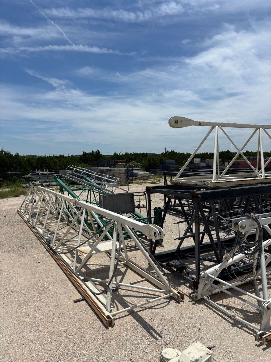 Metal scaffolding and construction materials under a partly cloudy sky.
