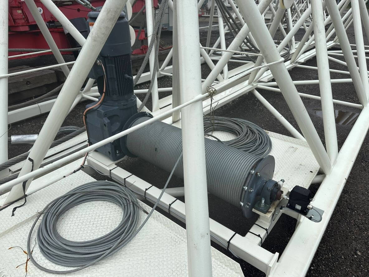 Close-up of a mechanical device with cables inside a metal framework.
