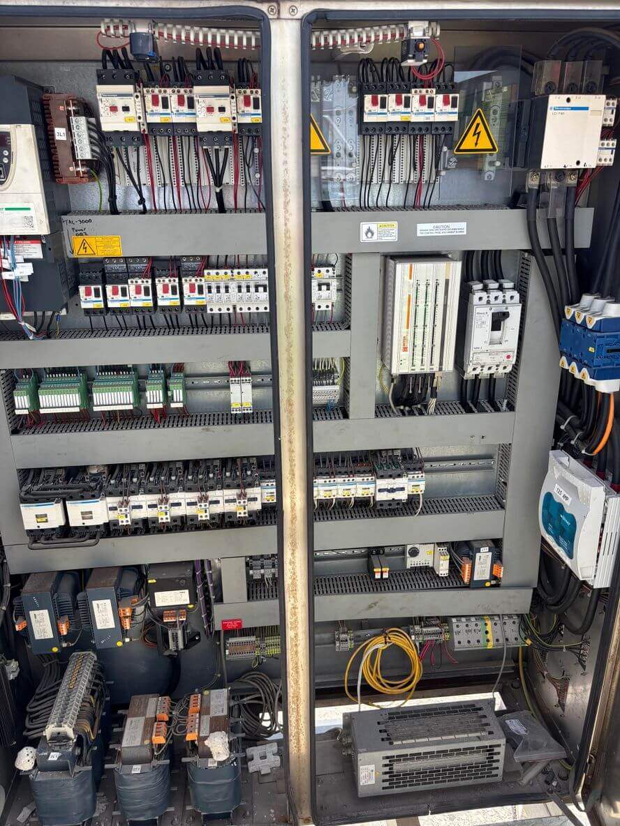 Electrical control panel with relays, circuit breakers, and wiring.