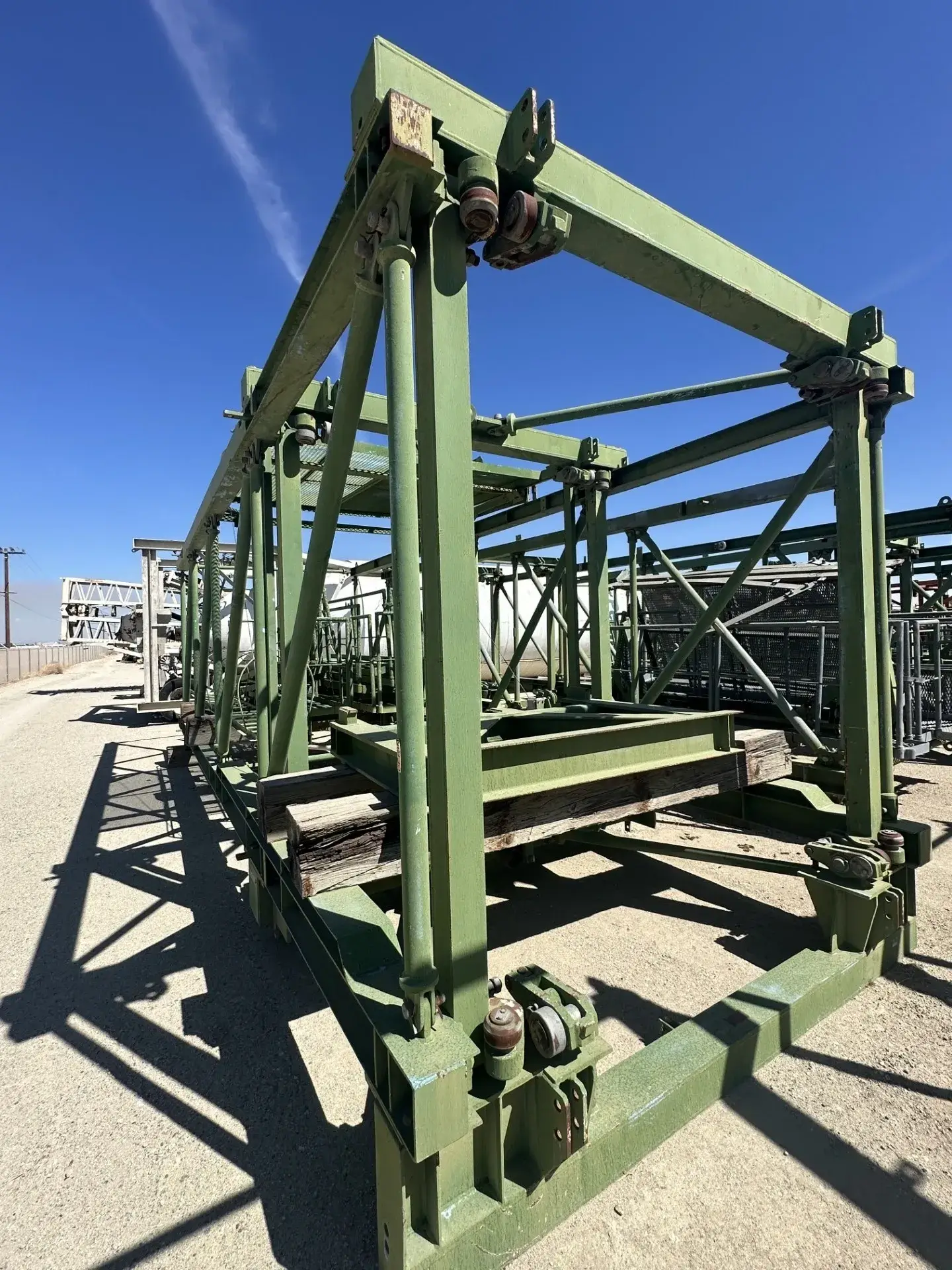 Green metal framework under blue sky.