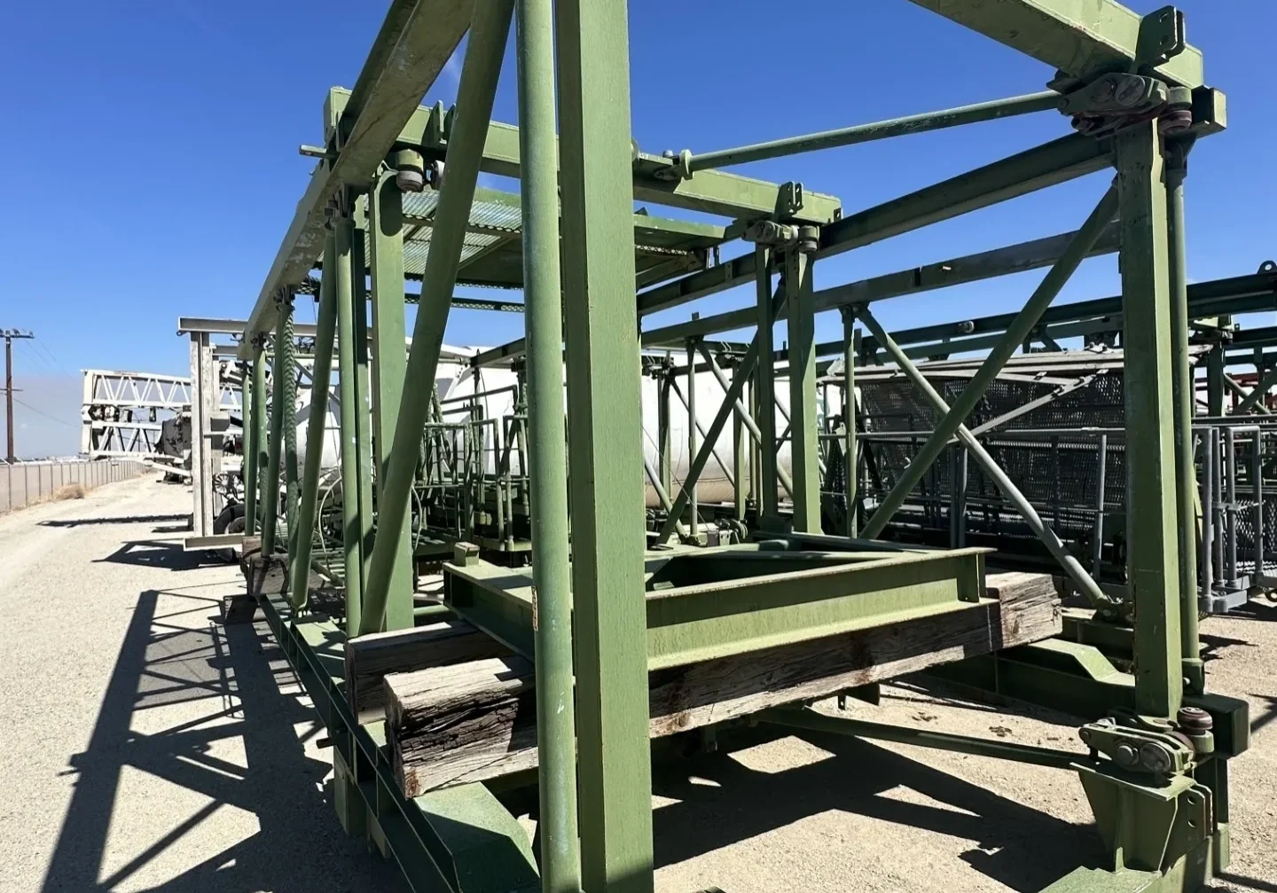 Green metal framework under blue sky.